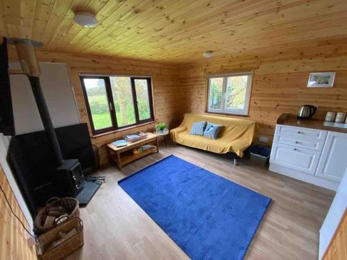 赫爾斯頓的住宿－Idyllic Cornish Retreat At Puffin Lodge，带沙发和蓝色地毯的客厅