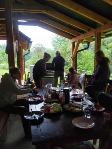 a group of people sitting around a wooden table with food at Chalupa Nonnetit in Vápenice