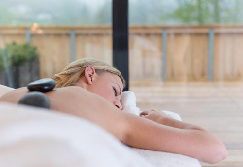 a woman laying in a bath tub at Das Graseck - mountain hideaway & health care in Garmisch-Partenkirchen