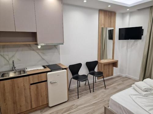 a kitchen with two chairs and a sink in a room at Joanna Suites in Sarandë