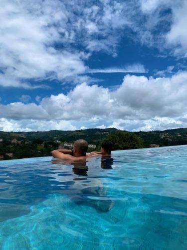 two people in the water in a swimming pool at Wanderlust Experience Hotel BW Signature - Campos do Jordão in Campos do Jordão