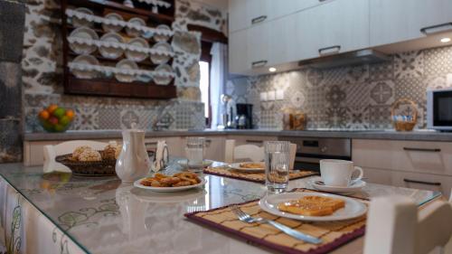 a kitchen with a table with plates of food on it at Petrino House Lasithi in Agios Georgios