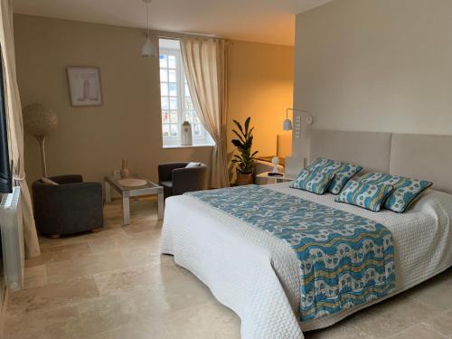 a bedroom with a large bed and a living room at EN VILLE à LA CAMPAGNE 2 in Louhans