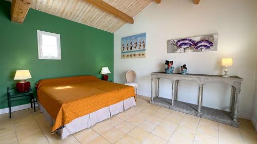 1 dormitorio con cama y pared verde en Magnifique villa avec piscine et billard en Saint-Martin-de-Ré