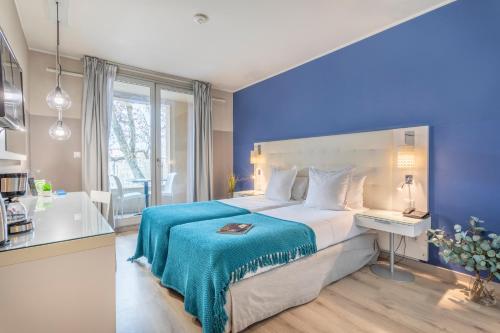 1 dormitorio con 1 cama grande y pared azul en Zenitude Hôtel Résidences Marseille Saint-Charles, en Marsella