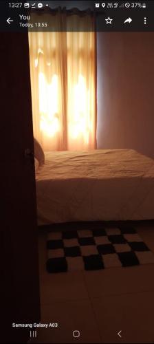 a bedroom with a bed and a window with a curtain at White villa resort dodangoda in Kalutara