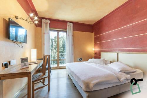 una camera con letto, scrivania e finestra di HOTIDAY Hotel Verona a Verona