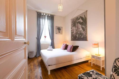 une chambre avec un lit blanc et une fenêtre dans l'établissement L'écrin des Ducs, à Dijon