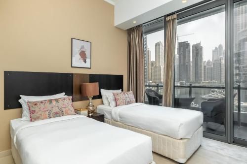 ein Hotelzimmer mit 2 Betten und einem Fenster in der Unterkunft Luton Vacation Homes -Silverene Tower Full marina view ,Dubai Marina A50AB7 in Dubai