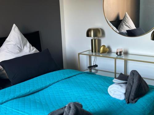 1 dormitorio con cama azul y espejo en Living Giessen by GB, en Giessen