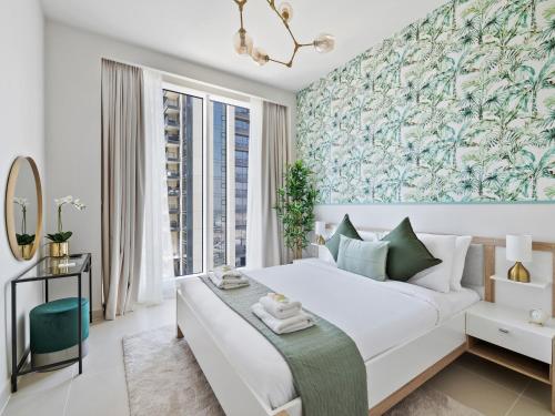 a bedroom with a large white bed with a blue and green wallpaper at Mesmerizing 2BDR in Creek Harbour HG1-1907 in Dubai