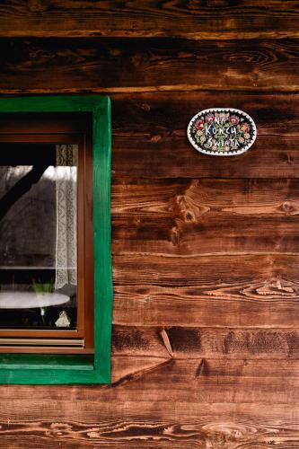 a window with a green frame on a wooden wall at Na końcu świata in Dubiecko