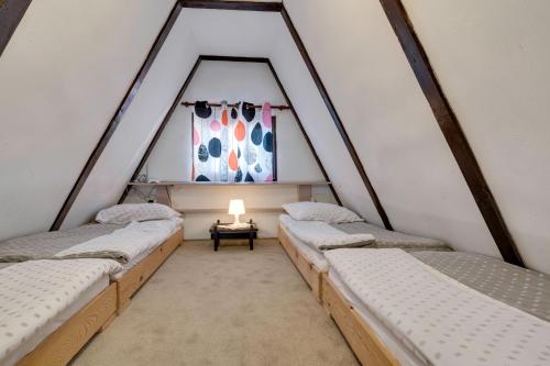 a group of beds in a room with a window at Story Mountain Chalet in Jahorina