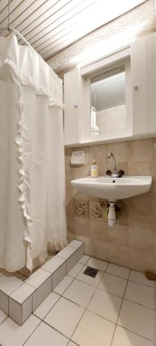 a bathroom with a sink and a shower curtain at Esperides Villa in Sani Beach