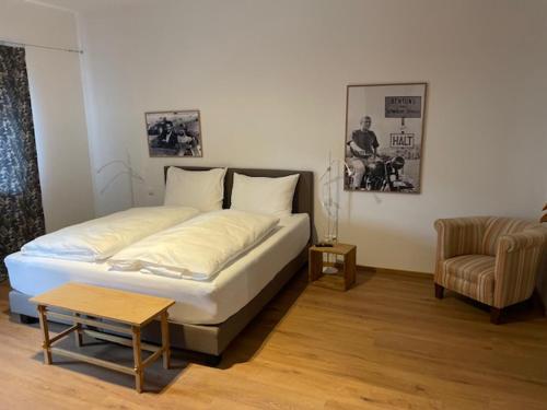 ein Schlafzimmer mit einem großen Bett und einem Stuhl in der Unterkunft "be-together" Engabrunn in Engabrunn