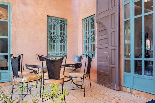 a patio with chairs and a table in front of a building at Villa Pauline with private pool & garden, hotel service and no insight. in Marrakech