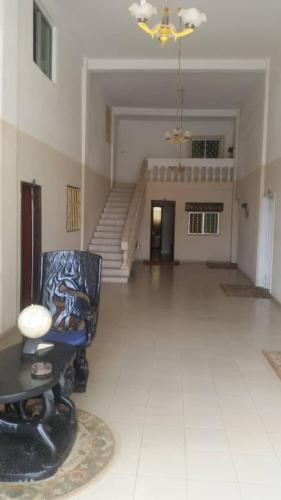 een woonkamer met een stoel en een trap bij #8 princess apartments, kerr serign,230mt to senegambia strip in Sere Kunda