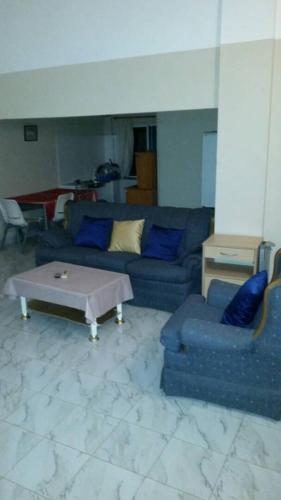 een woonkamer met een blauwe bank en een salontafel bij #8 princess apartments, kerr serign,230mt to senegambia strip in Sere Kunda