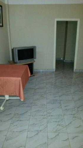 een kamer met een televisie en een tegelvloer bij #8 princess apartments, kerr serign,230mt to senegambia strip in Sere Kunda