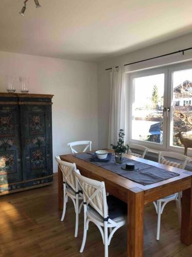 a dining room with a table and chairs and a window at Alpsoul eine Ferienwohnung mit Charisma…. in Garmisch-Partenkirchen
