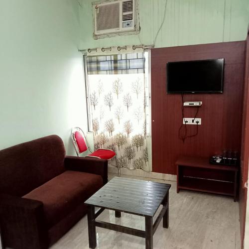 a living room with a couch and a table at HOTEL OASIS PALACE in Dālkola