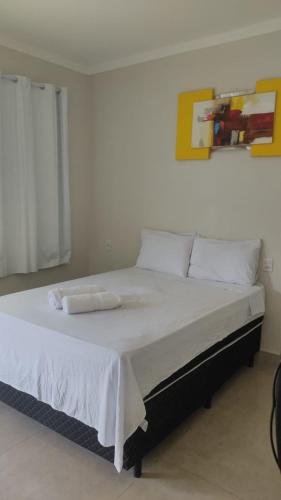 1 dormitorio con 1 cama con 2 toallas en Chalés Ipê do Lago, en Capitólio