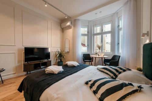 ノヴィサドにあるPorta Apartments Novi Sadのベッドルーム1室(大型ベッド1台、薄型テレビ付)