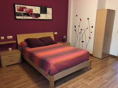 Un dormitorio con una cama con un cuadro en la pared. en A la Vera de Alarcón, en Motilla del Palancar