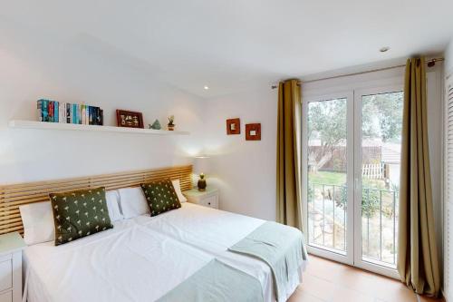 a white bedroom with a bed and a large window at Lesal Villas Rentals, Villa Mar Azul, Tossa de Mar in Tossa de Mar