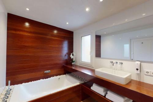 a bathroom with a tub and a sink and a mirror at Lesal Villas Rentals, Villa Mar Azul, Tossa de Mar in Tossa de Mar