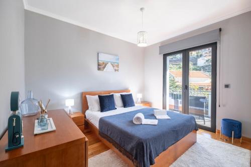 ein Schlafzimmer mit einem Bett und einem großen Fenster in der Unterkunft Yuri Big House in Ribeira Brava
