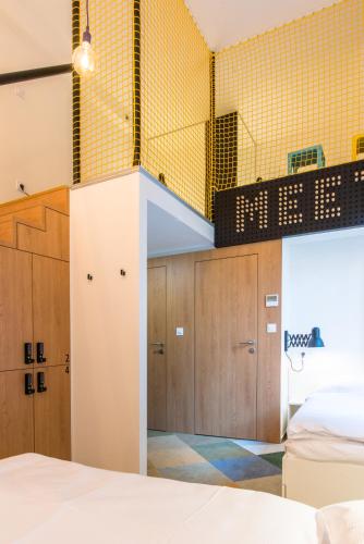 a bedroom with a bunk bed and yellow tiled walls at MeetMe23 in Prague