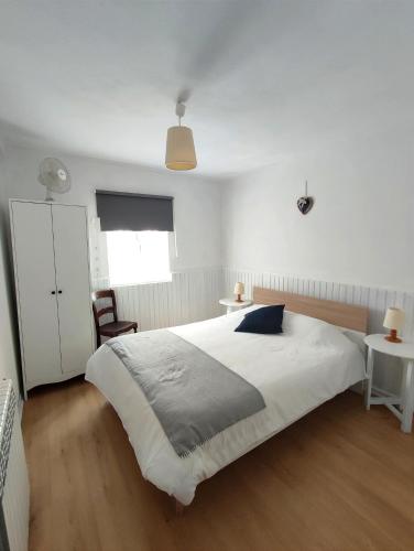a bedroom with a large white bed and a chair at Casa do Limoeiro 1 in Valezim