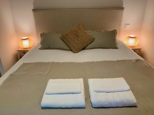ein Bett mit zwei Handtüchern darauf mit zwei Lampen in der Unterkunft Gite de charme avec piscine - a charming cottage gite with swimming pool in Saint-Léonard