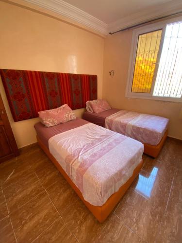 um quarto com 2 camas e uma janela em sandy shores camp appartements em Agadir