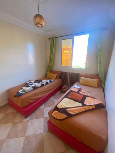um quarto com duas camas e uma janela em sandy shores camp appartements em Agadir