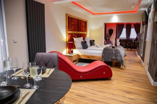 una camera d'albergo con letto e sedia rossa di exkl. romantisches SM Apartment Black Rose a Gifhorn