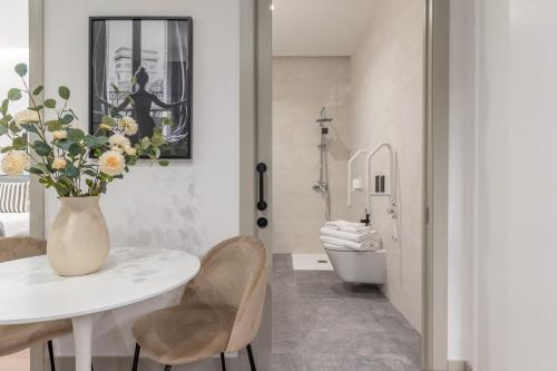 een badkamer met een witte tafel en stoelen en een toilet bij 2 single beds in Chamberi Quevedo III in Madrid