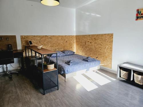 a bedroom with a bed and a desk in a room at Le studio de Max - Terrasse et Parking in Valence