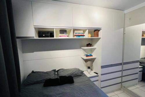 a bedroom with a bed and shelves on the wall at Apartamento Home Practice Flat in São Luís