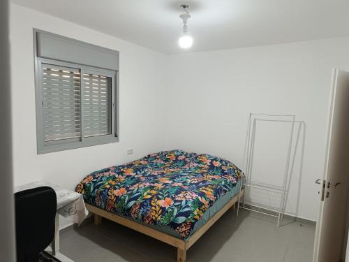 a bedroom with a bed and a window at Lovely room at Benny's apartment in Netivot