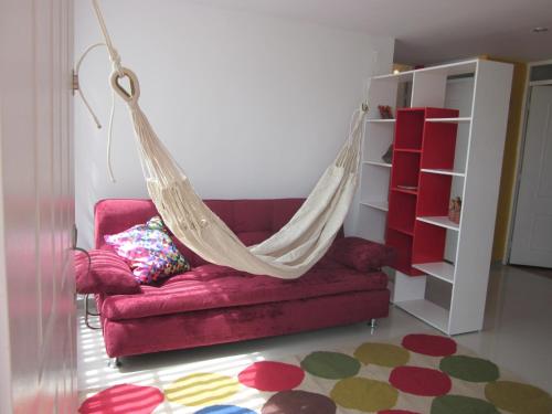 un sofá rojo con una hamaca en una habitación en Apartamento terrazas de cajica, en Cajicá
