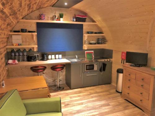 a kitchen in a log cabin with a sink and a stove at Kendoon Cabin in Carsphairn