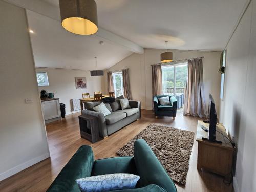 a living room with a couch and a table at Two Bedroom Lodge In The Country - Owl, Peacock & Meadow in Liskeard