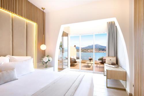 a bedroom with a bed and a view of the ocean at Hôtel Marinca & Spa in Olmeto