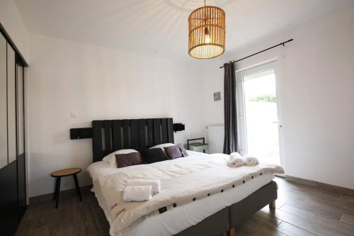 sypialnia z dużym łóżkiem i żyrandolem w obiekcie Maison SYRAH w mieście Condrieu