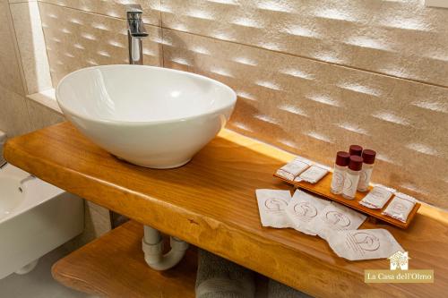 un bagno con lavandino a ciotola su un tavolo in legno di La Casa dell'Olmo - Suite Apartment Cuneo a Cuneo
