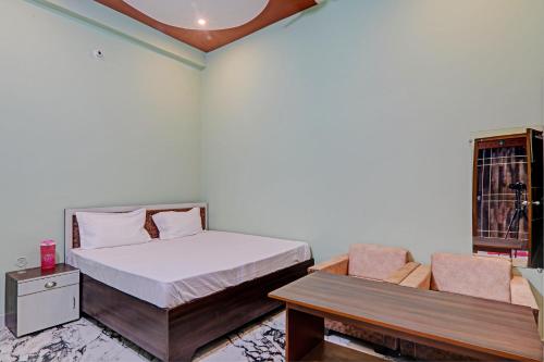 SultānpurにあるOYO Green Valley Guest Houseのベッドルーム1室(ベッド1台、テーブル、ベンチ付)