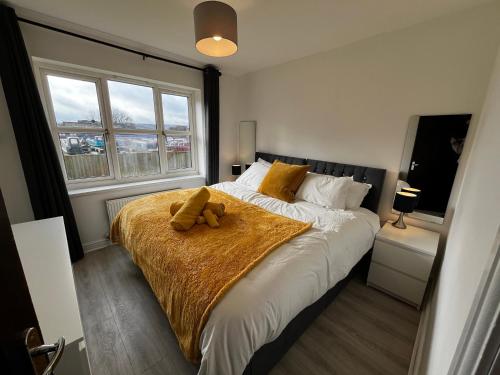 ein Schlafzimmer mit einem Bett mit einem Teddybär drauf in der Unterkunft Central flat, Alton Towers, Waterworld in Stoke on Trent