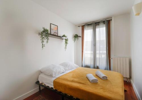 1 dormitorio con 1 cama con 2 toallas en Le CENTRE VILLE de Bezons en Bezons